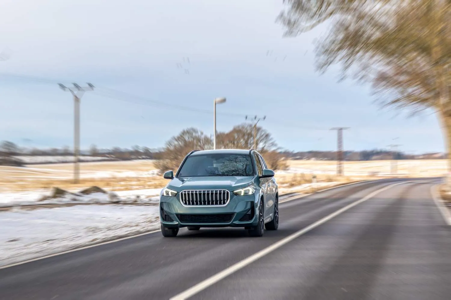 Car traveling down a quiet two lane road in winter light